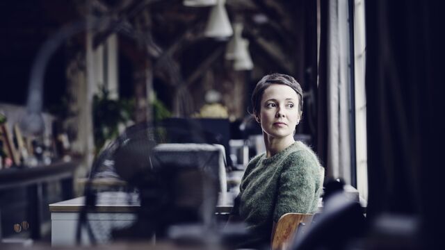Businesswoman at workstation looking out window SMALL